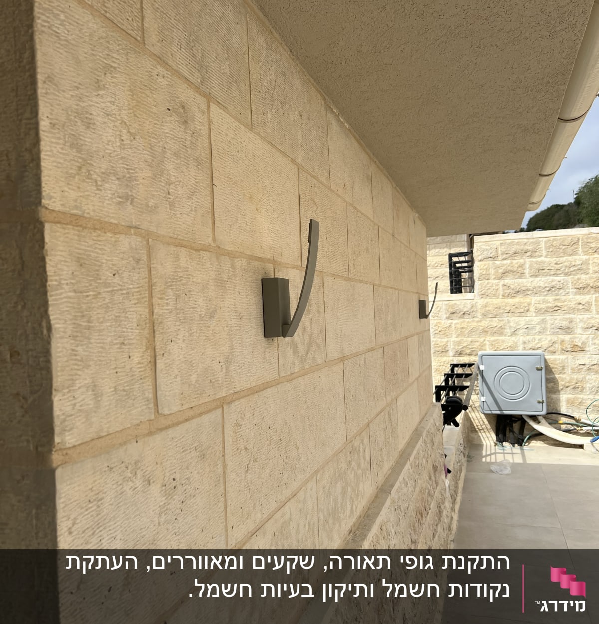 תיבת חשמל על קיר אבן עם חוטים חשמליים